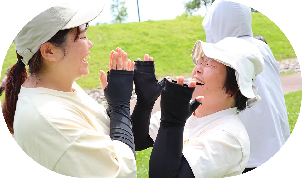 女性二人が向かい合って、笑顔で笑っている