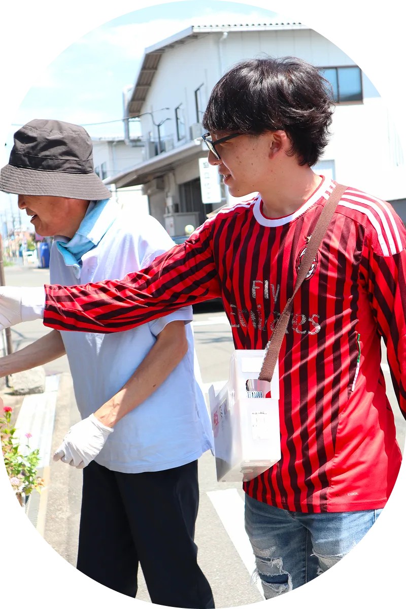 男性が利用者の畑作業をサポートしている